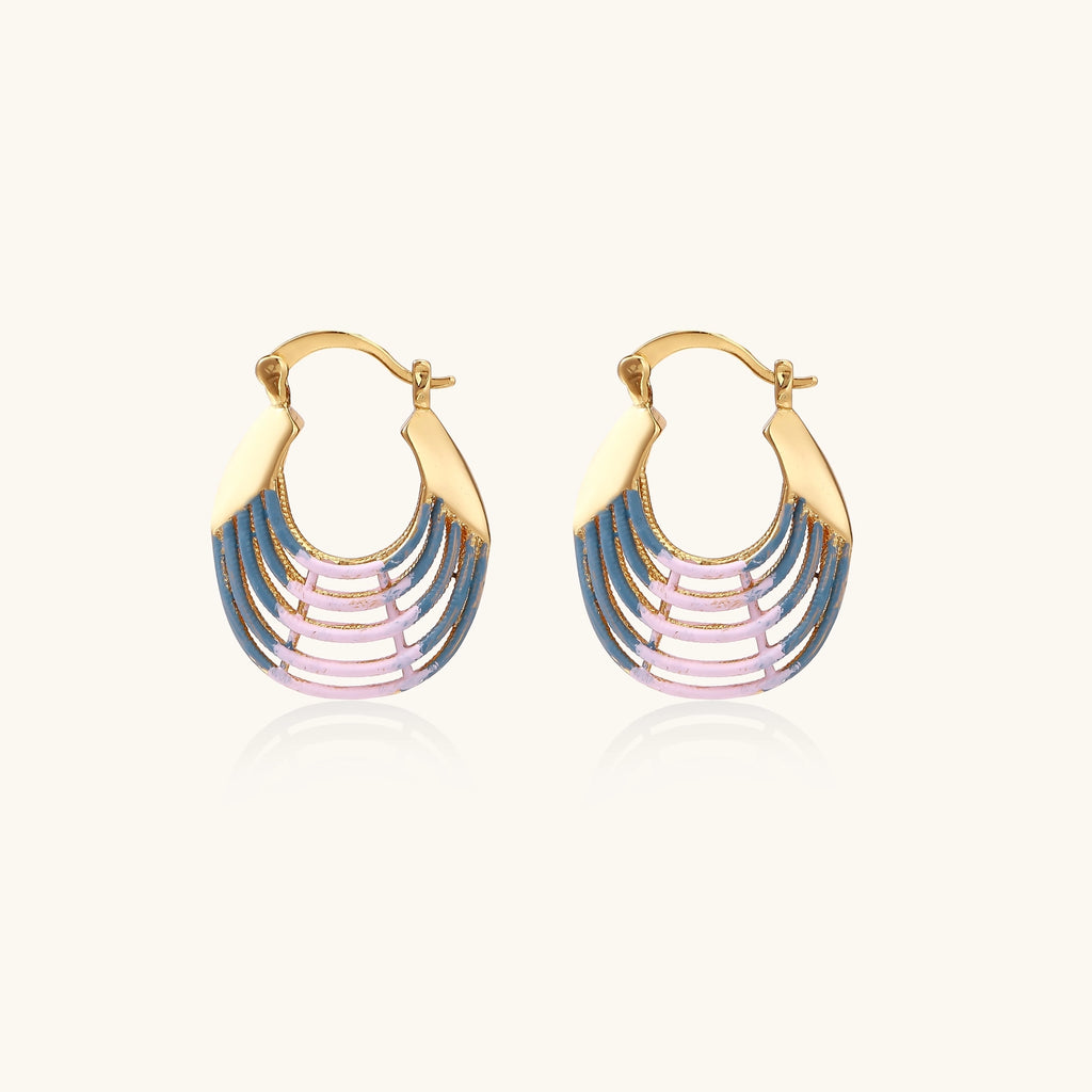 Gold hoop earrings with gradient blue-to-pink enamel in ribbed fan design on beige background