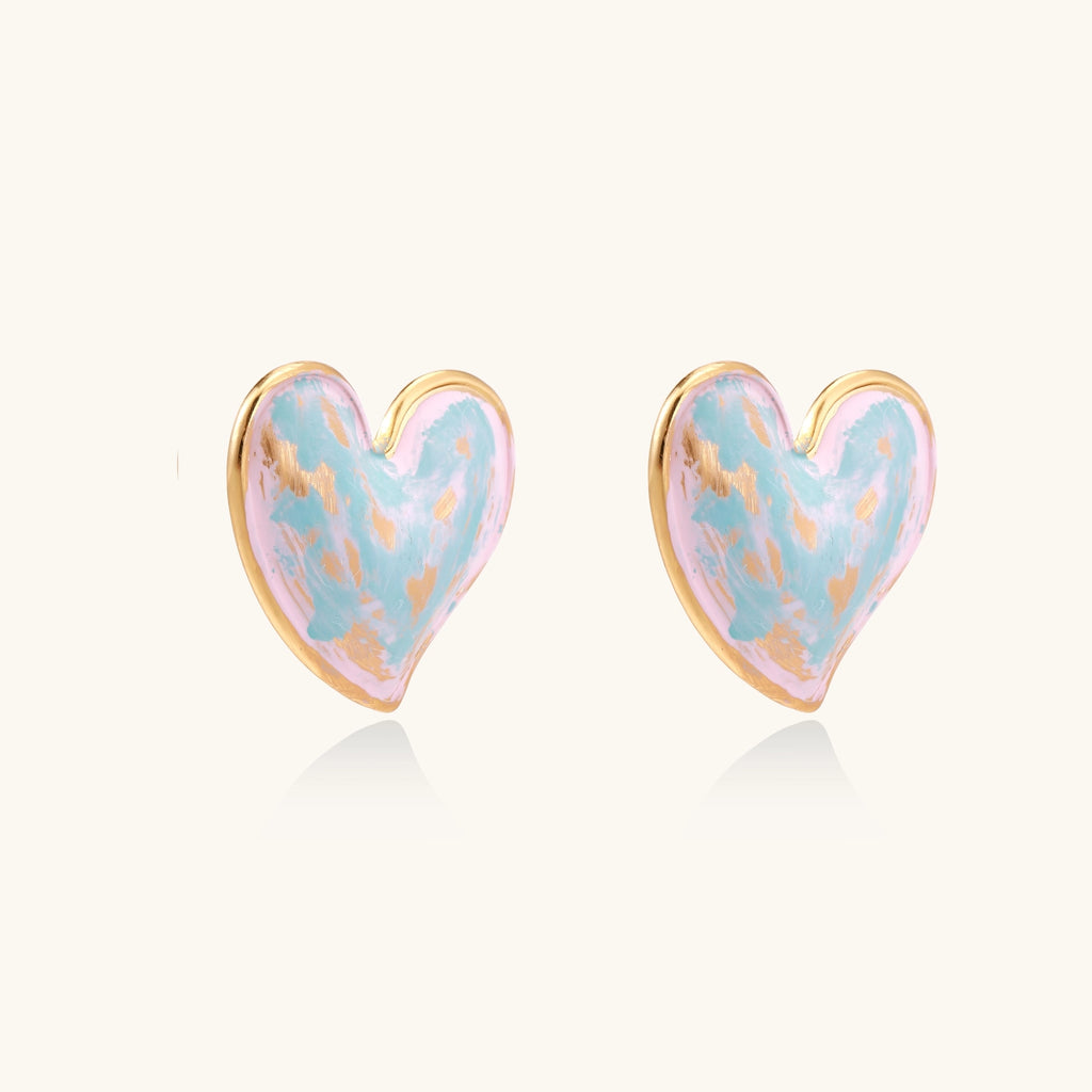 Heart-shaped stud earrings with swirled turquoise and pink enamel in gold-plated frames on cream background