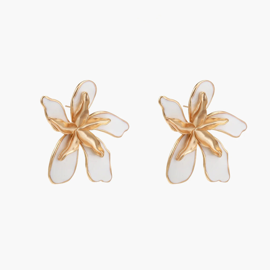 White enamel tropical flower earrings with sculptural gold-plated center and organic petal design on cream background
