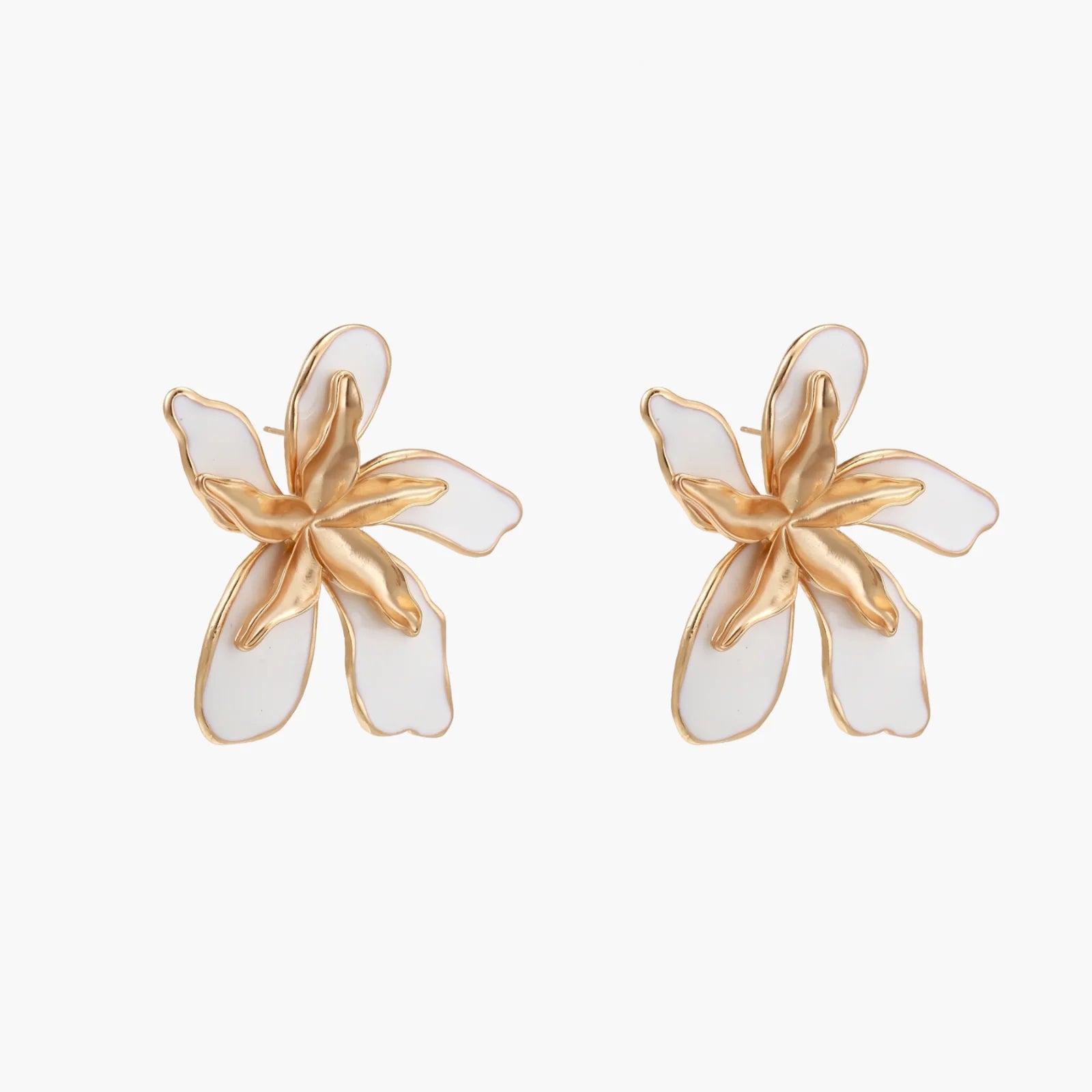 White enamel tropical flower earrings with sculptural gold-plated center and organic petal design on cream background