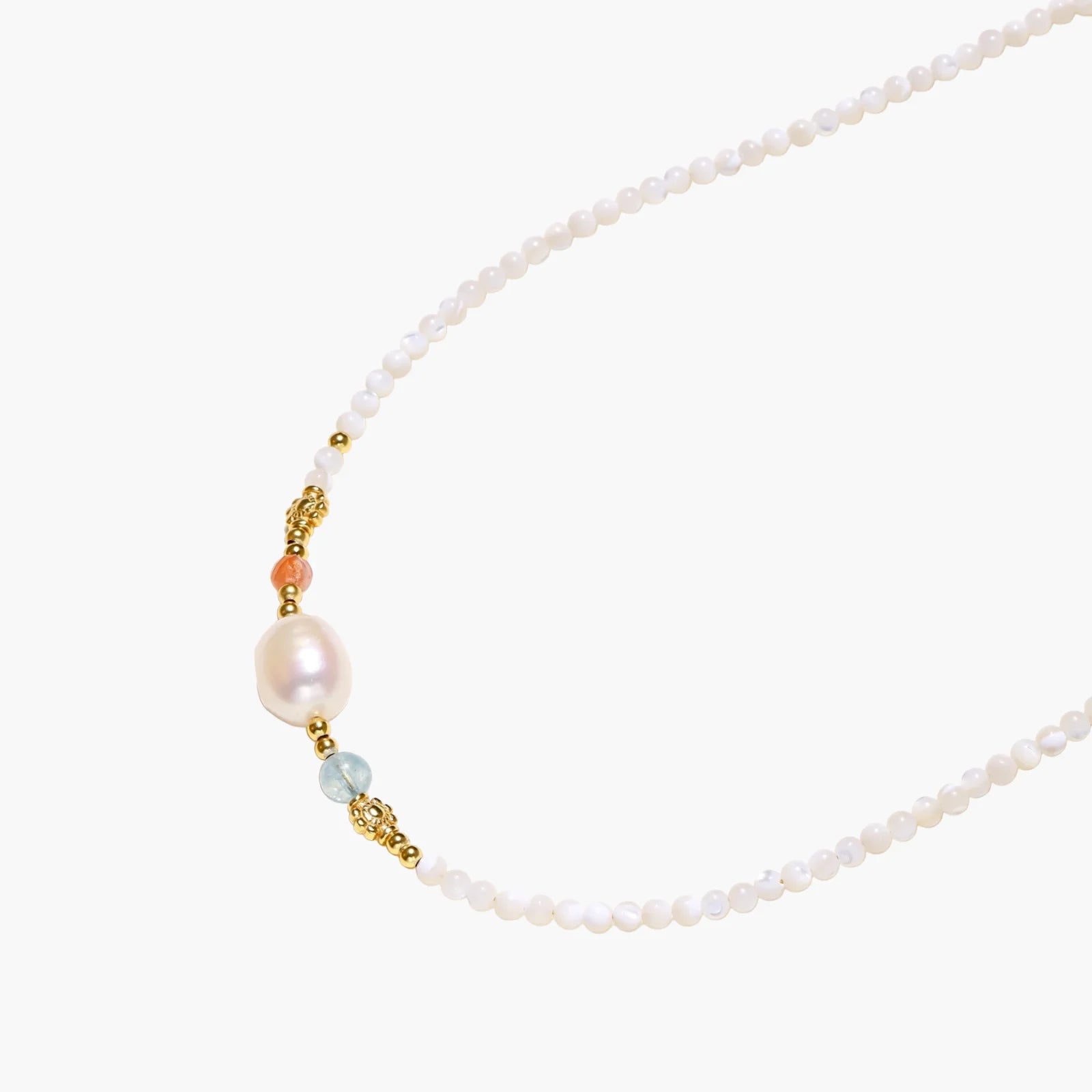 Delicate white beaded necklace with baroque pearl center, gold accents, and coral and aqua gemstones on cream background.