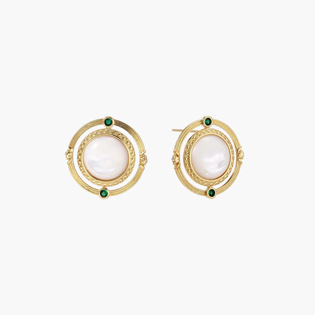 Circular gold stud earrings with iridescent mother-of-pearl center and green zirconia accents on cream background.