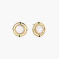 Circular gold stud earrings with iridescent mother-of-pearl center and green zirconia accents on cream background.