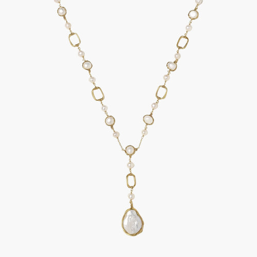 Y-shaped gold necklace with alternating geometric links, freshwater pearls, and baroque pearl pendant on cream background