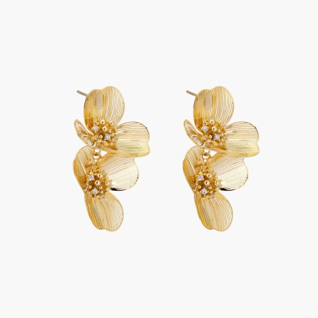 Pair of gold-plated double flower earrings with textured petals and crystal centers on cream background.