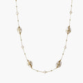 Long gold chain necklace with baroque pearls wrapped in leaf designs and small freshwater pearls spaced along the strand