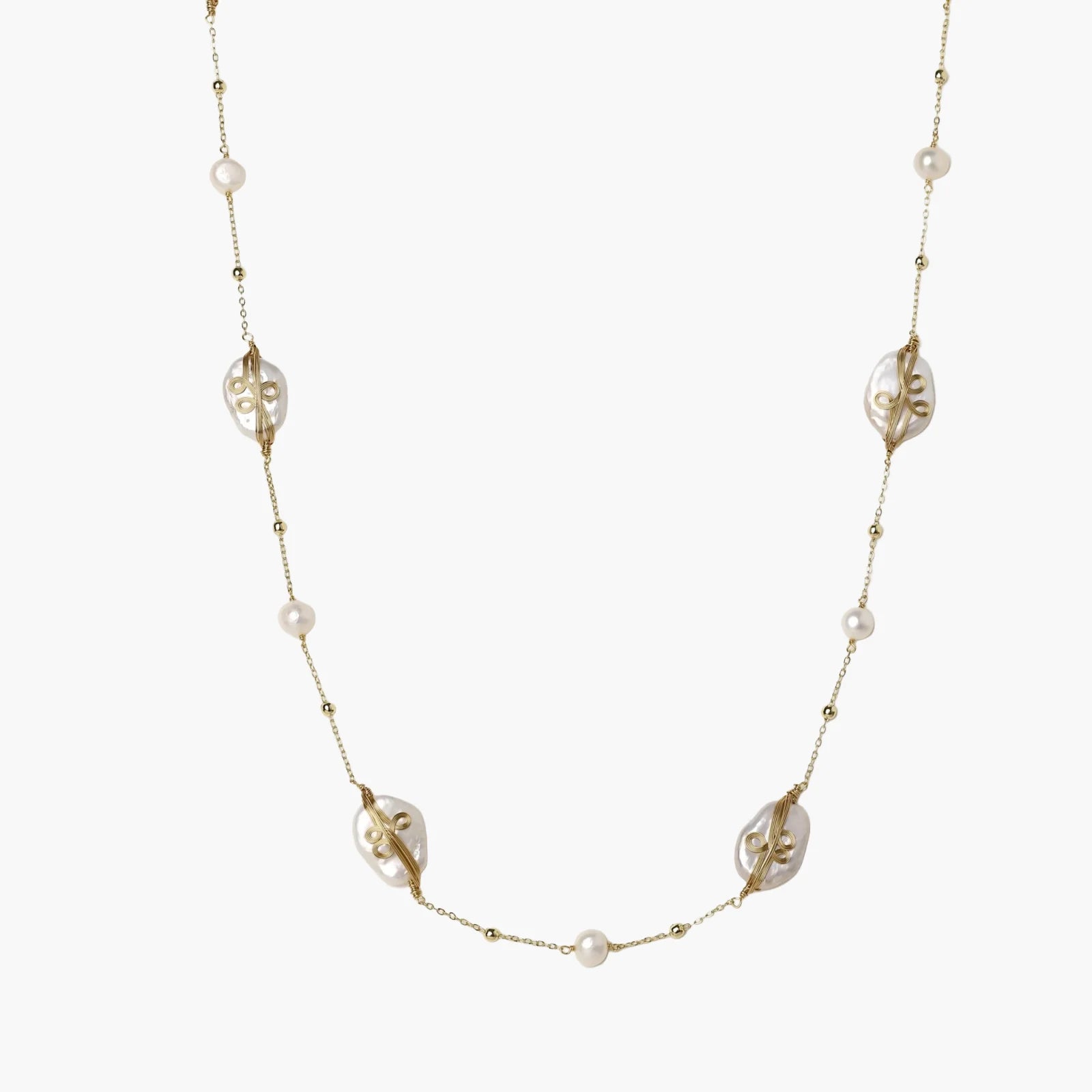 Long gold chain necklace with baroque pearls wrapped in leaf designs and small freshwater pearls spaced along the strand
