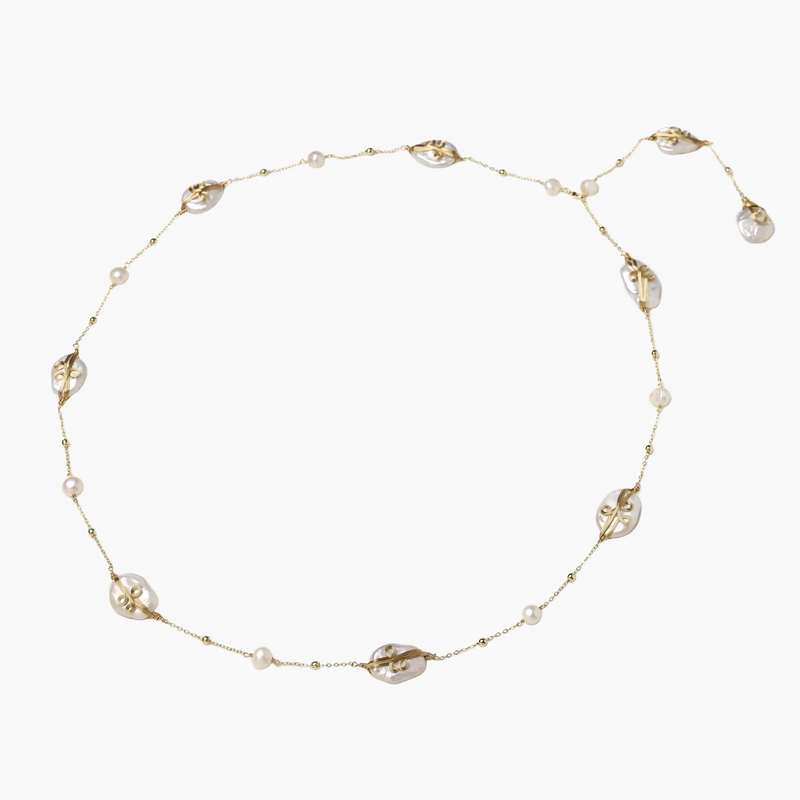 Long gold chain necklace with baroque pearls wrapped in leaf designs and small freshwater pearls spaced along the strand