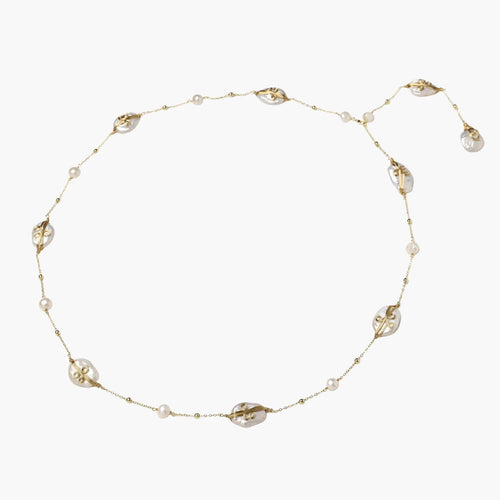 Long gold chain necklace with baroque pearls wrapped in leaf designs and small freshwater pearls spaced along the strand