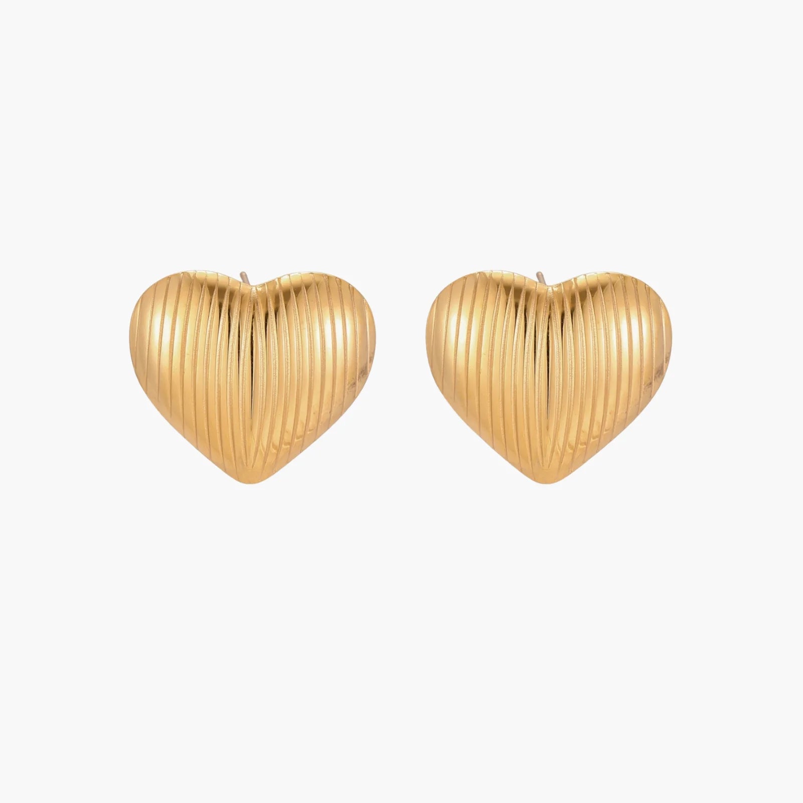 Gold heart-shaped stud earrings with parallel ridged texture on cream background