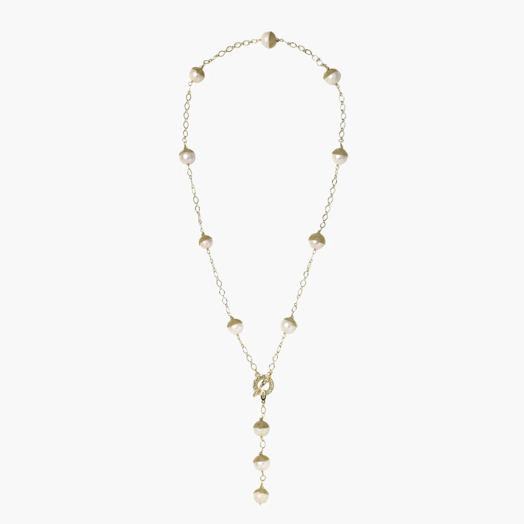 Gold-plated lariat necklace with baroque pearls and textured caps on cream background, showing adjustable Y-shaped design.