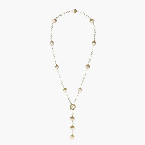 Gold-plated lariat necklace with baroque pearls and textured caps on cream background, showing adjustable Y-shaped design.