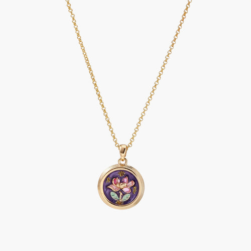 Gold-plated circular pendant with hand-painted purple enamel floral design on delicate chain against cream background