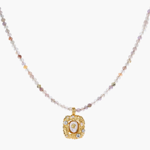 Ornate gold-plated pendant necklace with multicolored gemstone beads in purple, pink and clear tones on white background