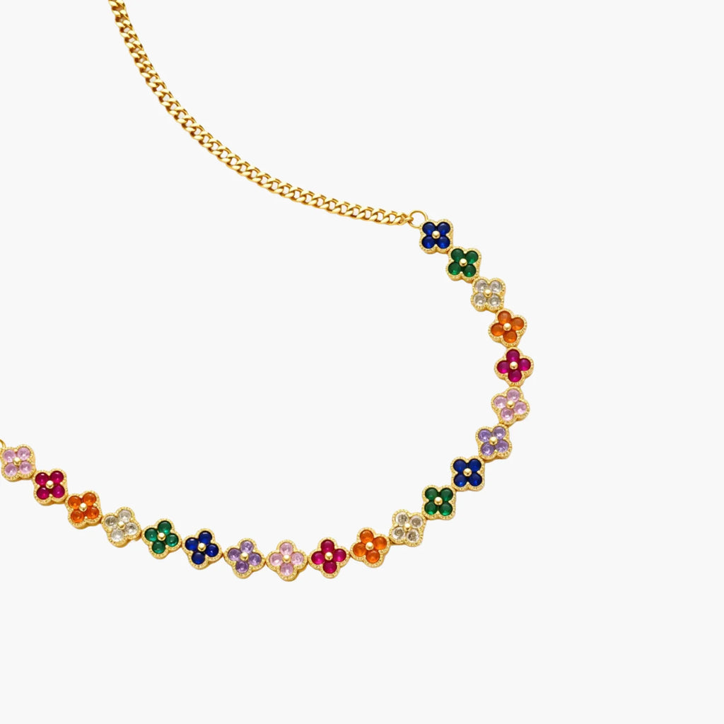 Colorful four-leaf clover jewelry set with rainbow cubic zirconia stones in gold-plated setting on white background