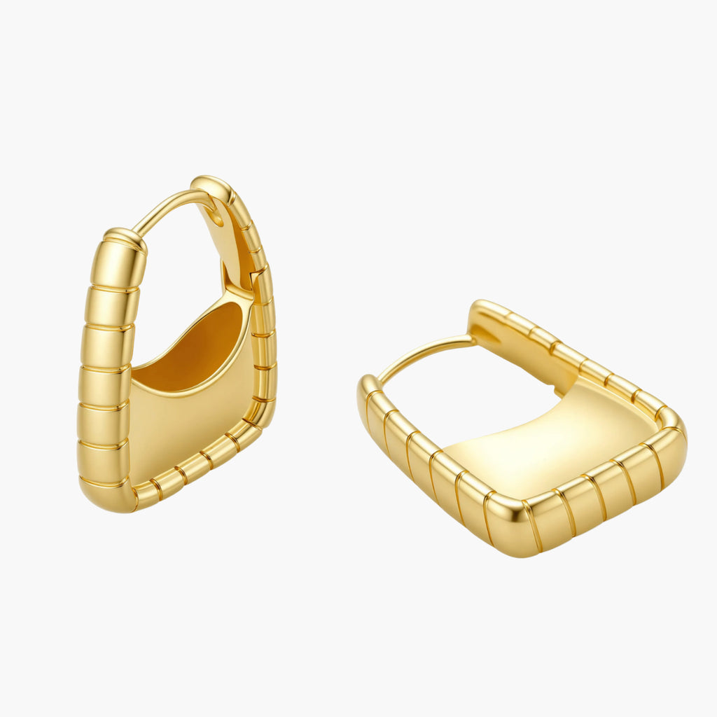 Chunky segmented gold-plated huggie hoop earrings with bamboo-inspired geometric design on white background.