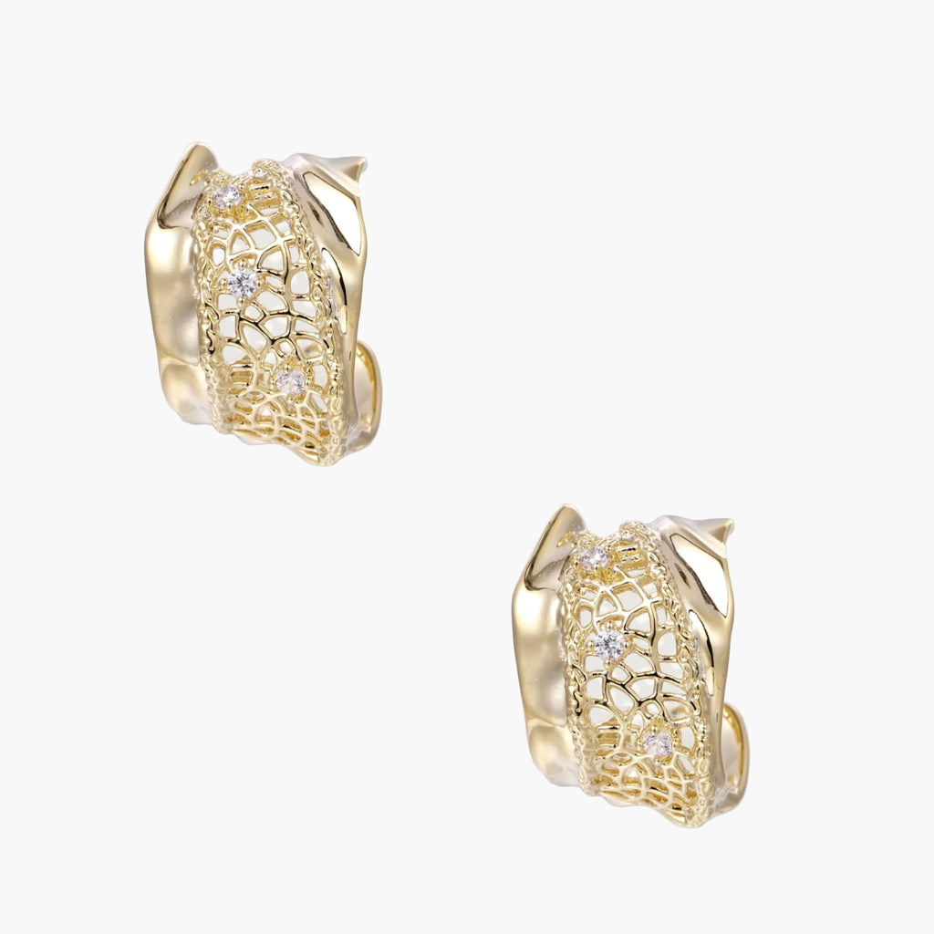 Gold-plated sculptural hoop earrings with geometric lattice centerband and sparkling zirconia on white background.