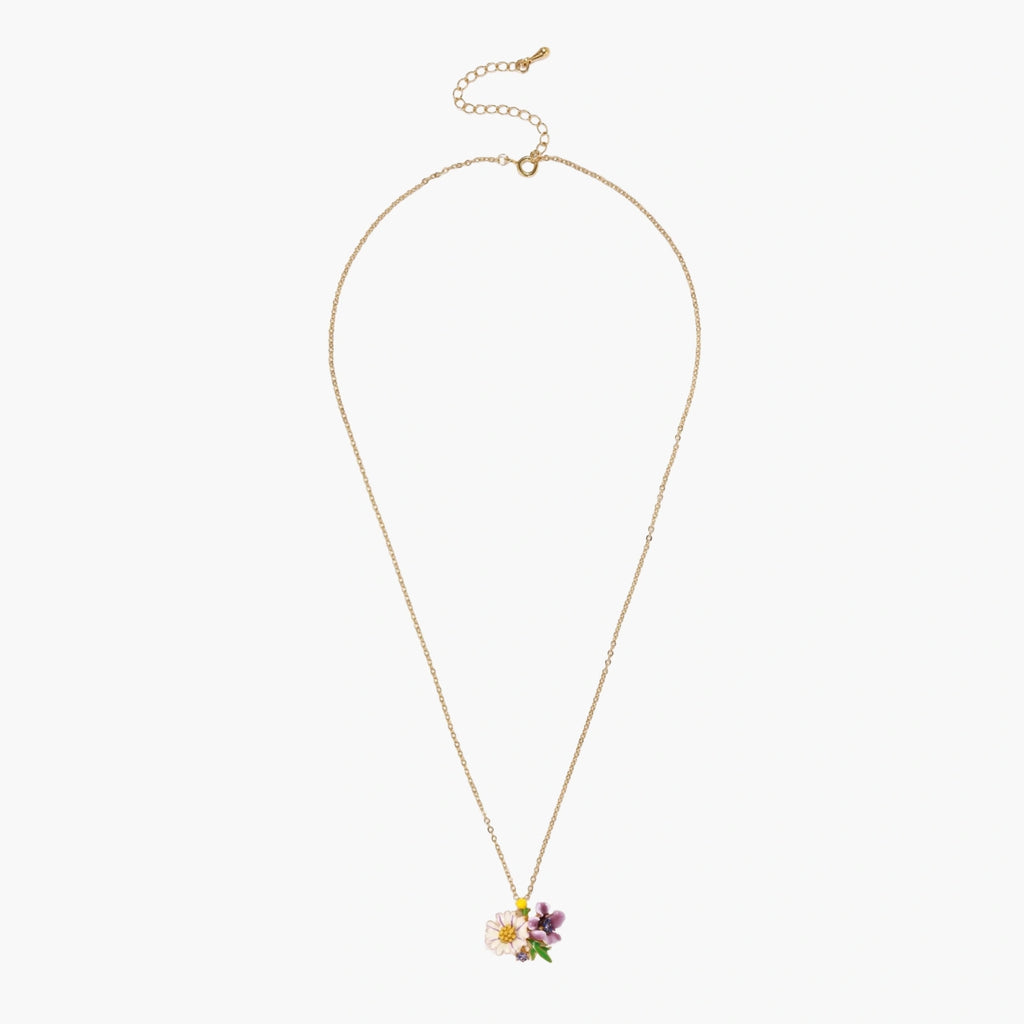 Gold-plated necklace with pink and purple enamel flower pendant featuring crystal accents on cream background