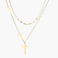 Three-layered gold necklace set with graduated cross pendants in mixed chain styles on white background.