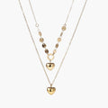 Three-layer 14K gold plated necklace with coin discs and dual heart pendants on cream background