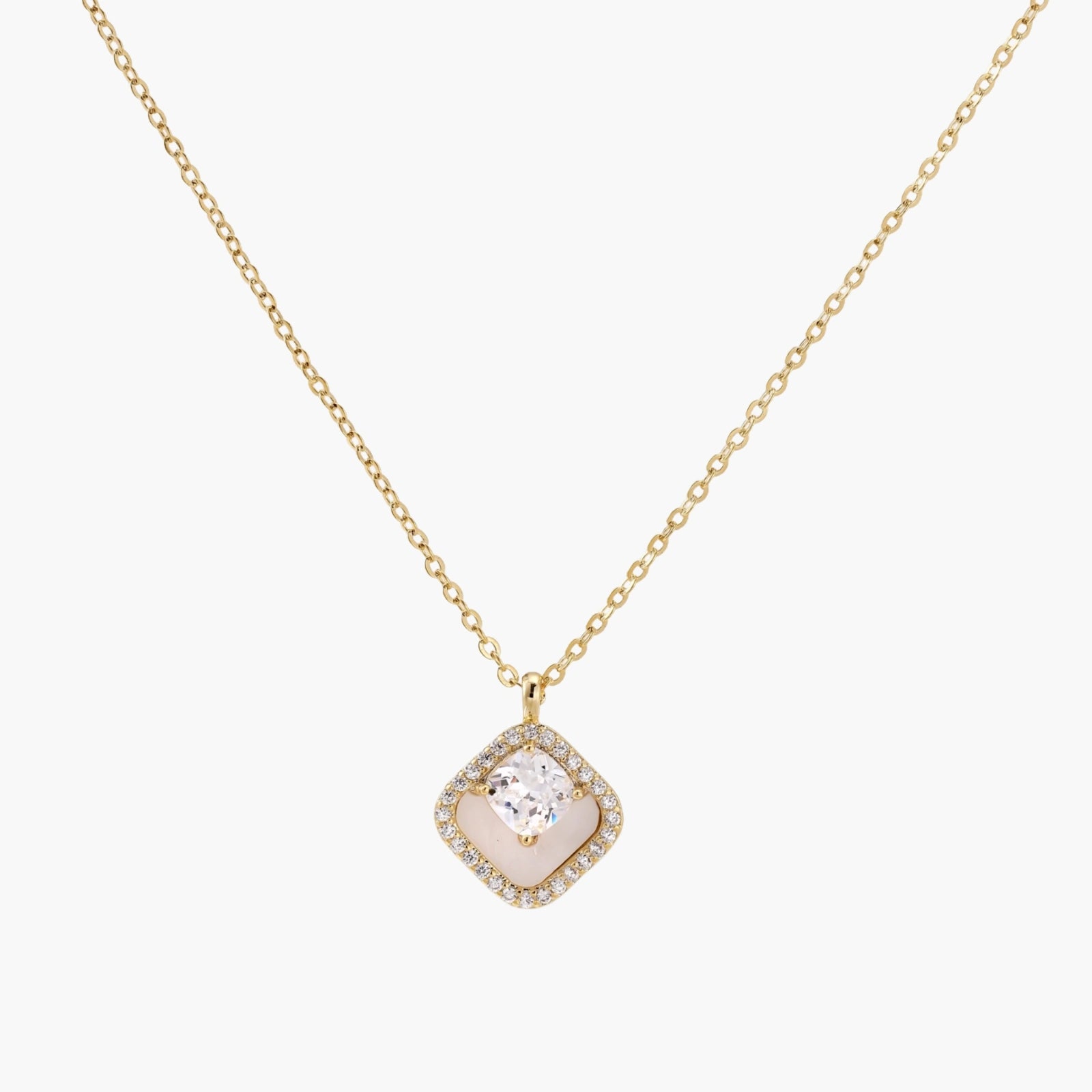 Gold quatrefoil pendant with crystal center on iridescent mother-of-pearl base, adjustable gold chain on cream background
