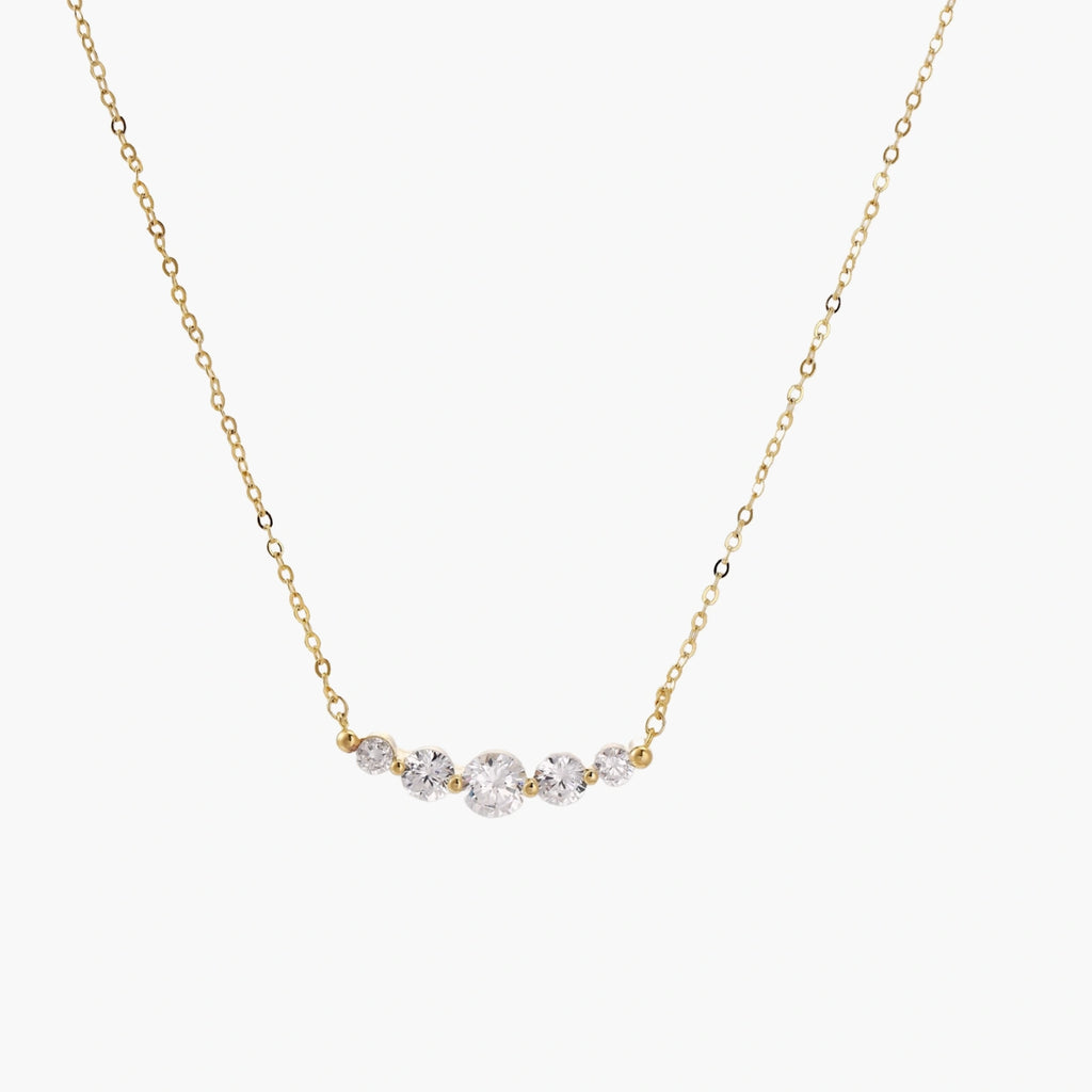 Delicate 14K gold-plated necklace with five graduated zirconia stones arranged in a curved arc on fine chain