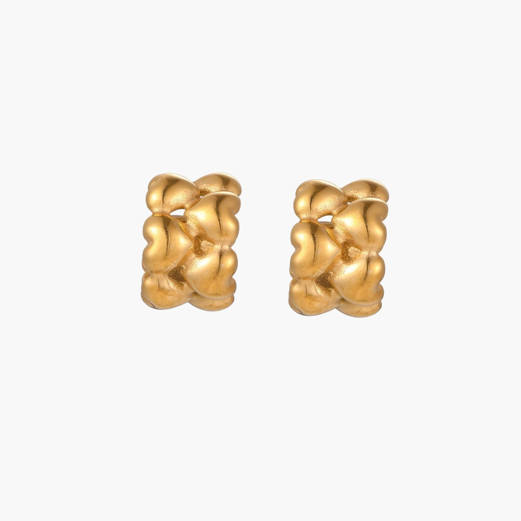 Close-up of gold-plated twisted rope huggie hoop earrings with brushed finish on white background.