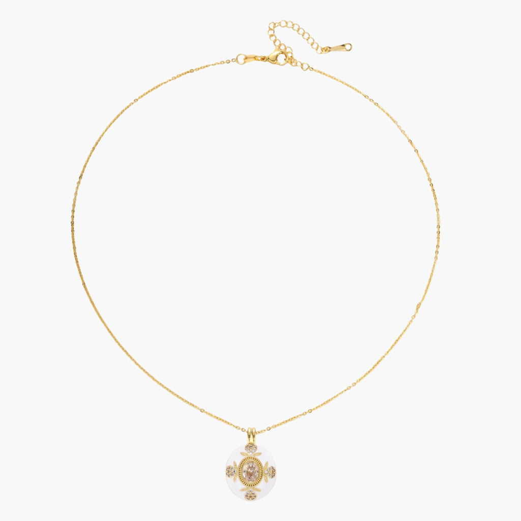 Gold-plated necklace with circular white enamel pendant featuring central zirconia stone and ornate decorative details