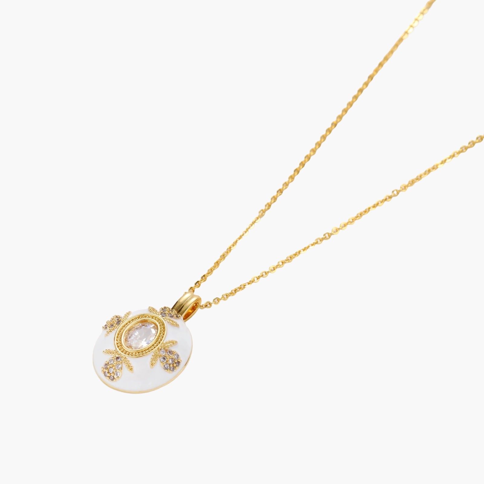 Gold-plated necklace with circular white enamel pendant featuring central zirconia stone and ornate decorative details